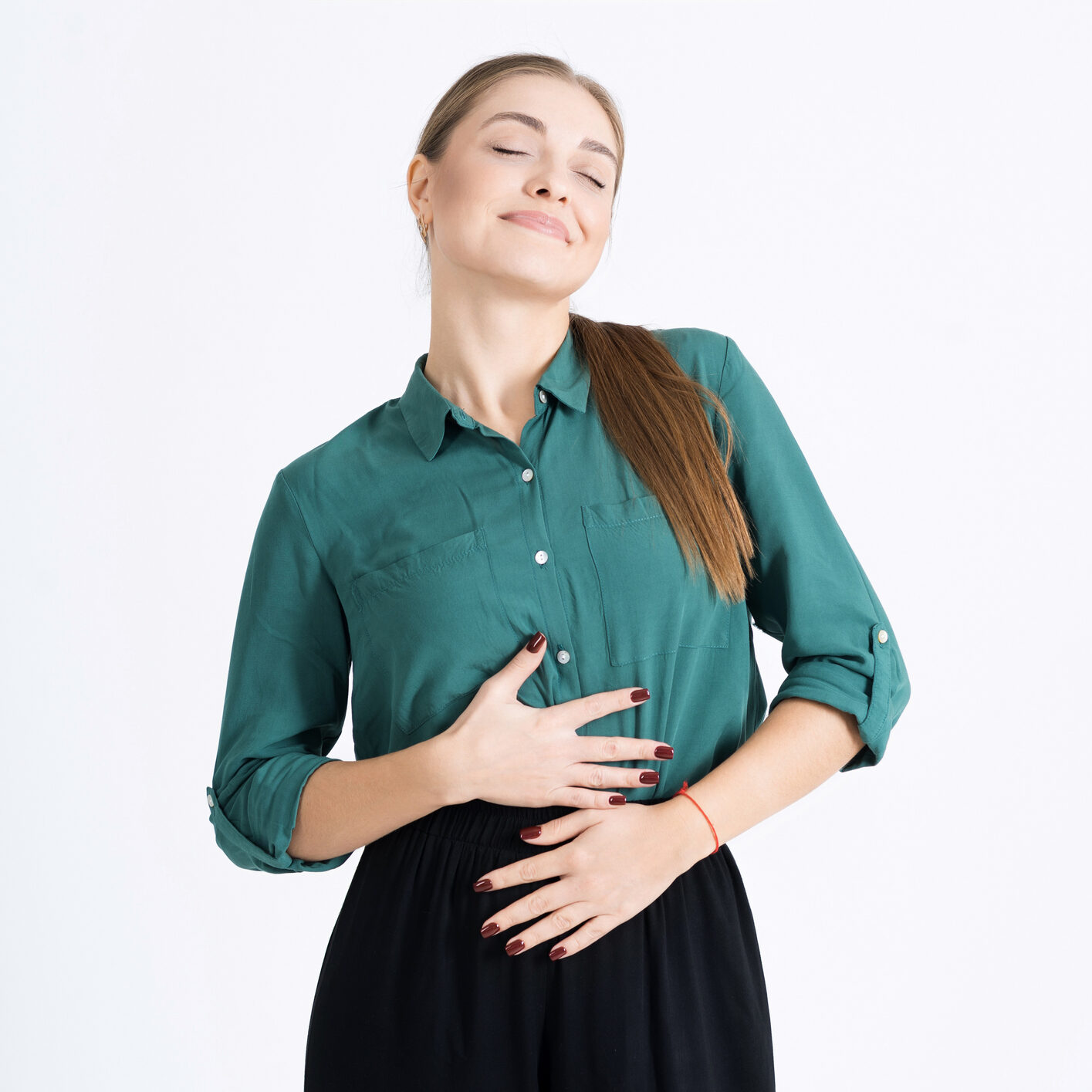 Attractive young woman touches her stomach after a delicious meal isolated on a white studio background. The girl is pregnant, she is an expectant mother. Pregnancy, motherhood.